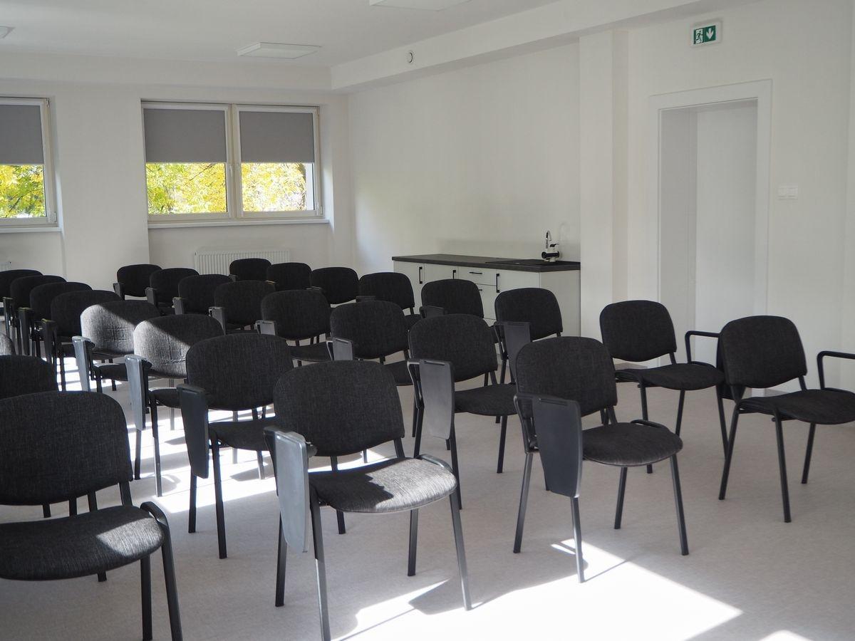 Sala szkoleniowa wyposażona w krzesła z pulpitami do notowania, przeznaczona do prowadzenia kursów, wykładów i szkoleń. 