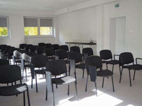 Sala szkoleniowa wyposażona w krzesła z pulpitami do notowania, przeznaczona do prowadzenia kursów, wykładów i szkoleń. 